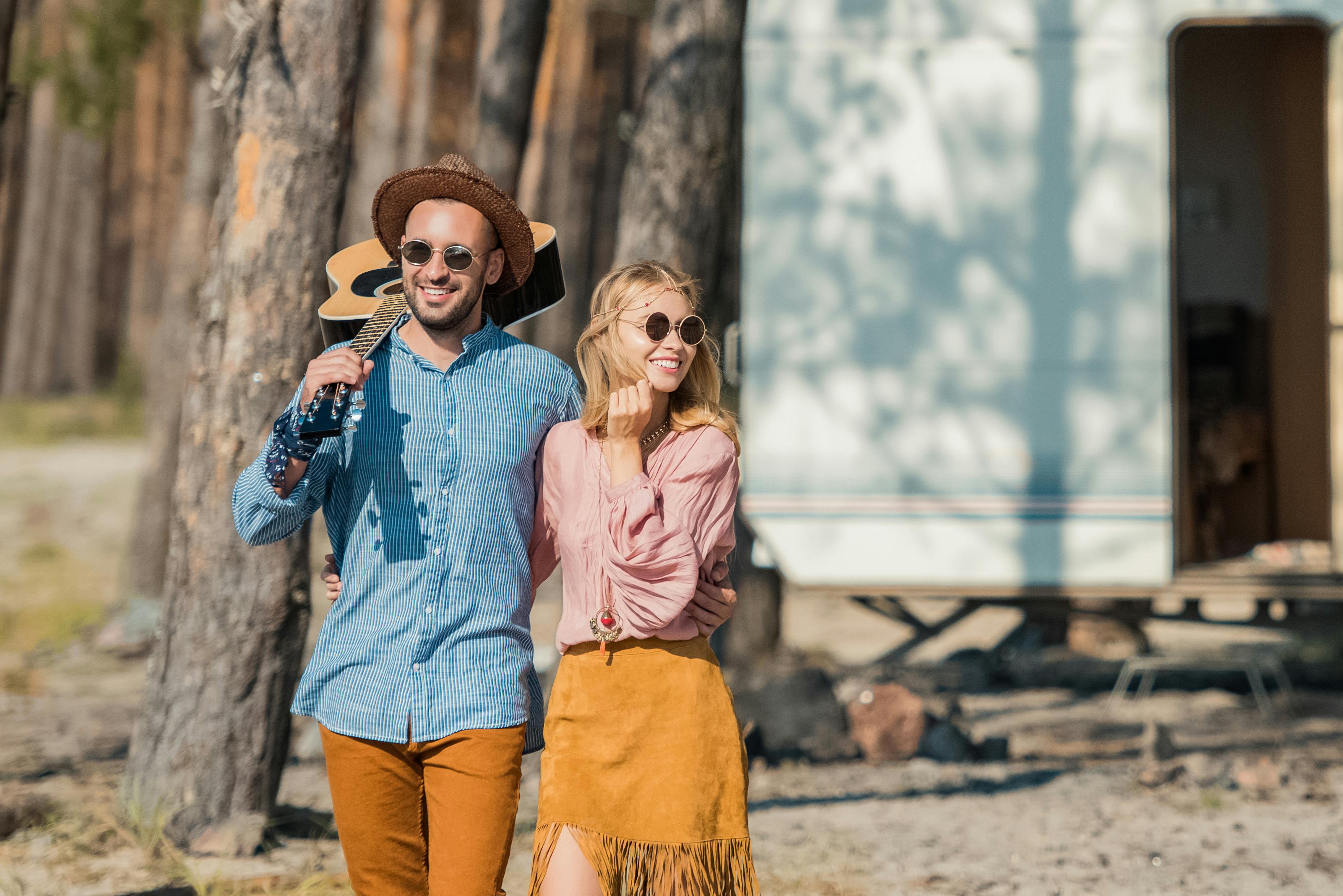 Young hippie couple hugging and standing with guit