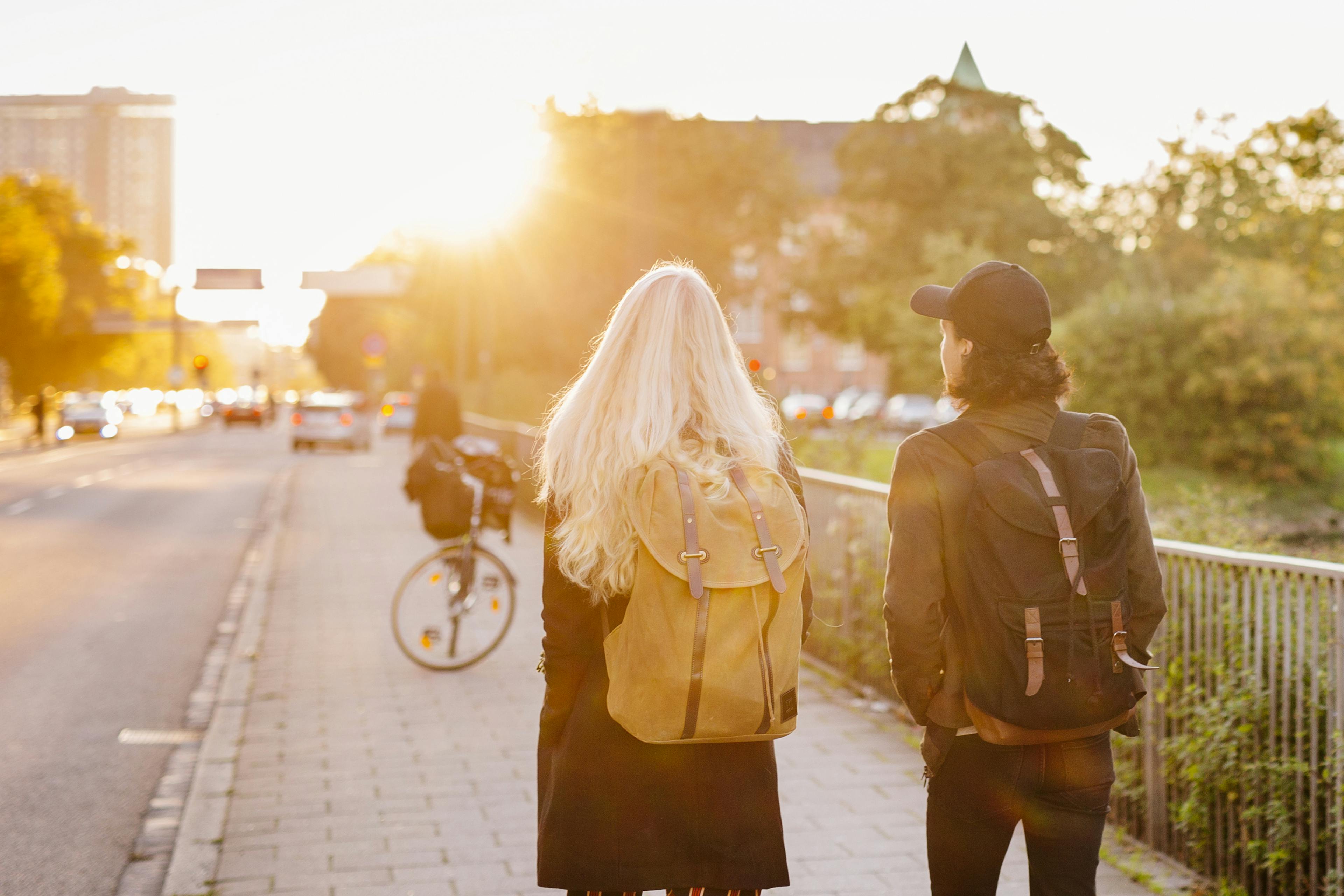 Rear view of teenage friends walking on footpath
