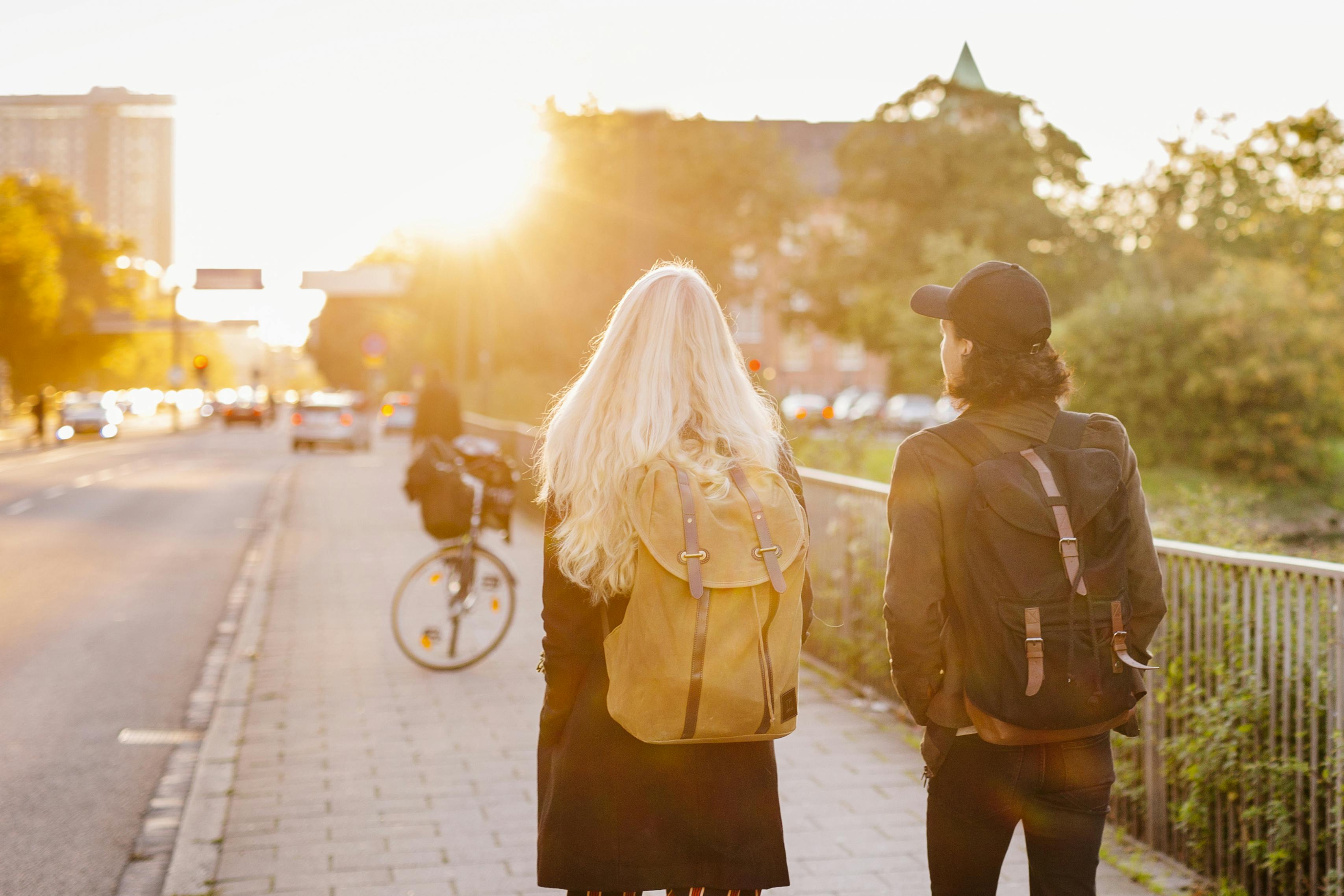 Rear view of teenage friends walking on footpath
