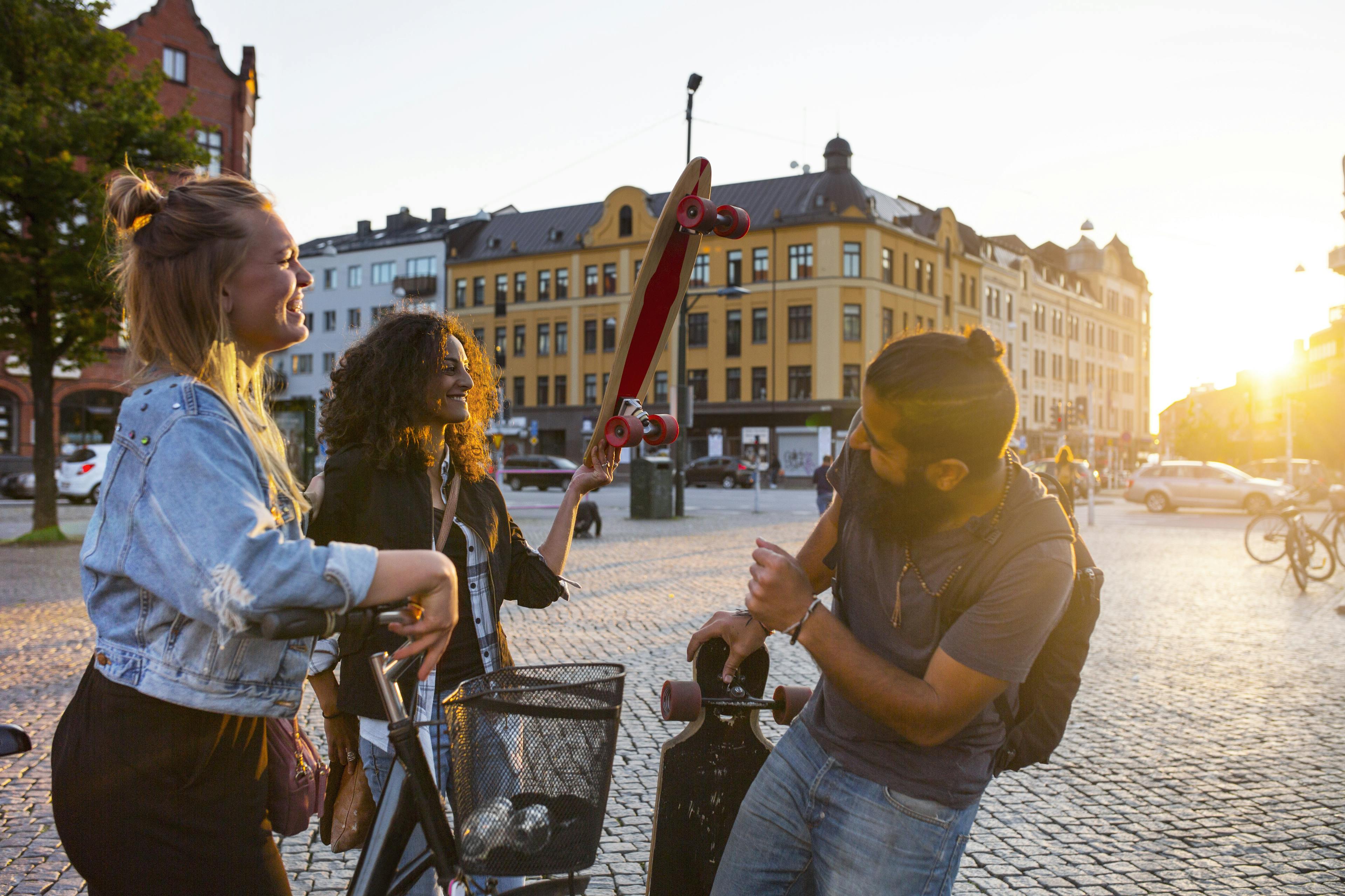 Smiling friends with bicycle and longboards