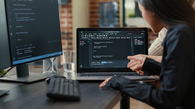 Woman working on a laptop showing sourcecode