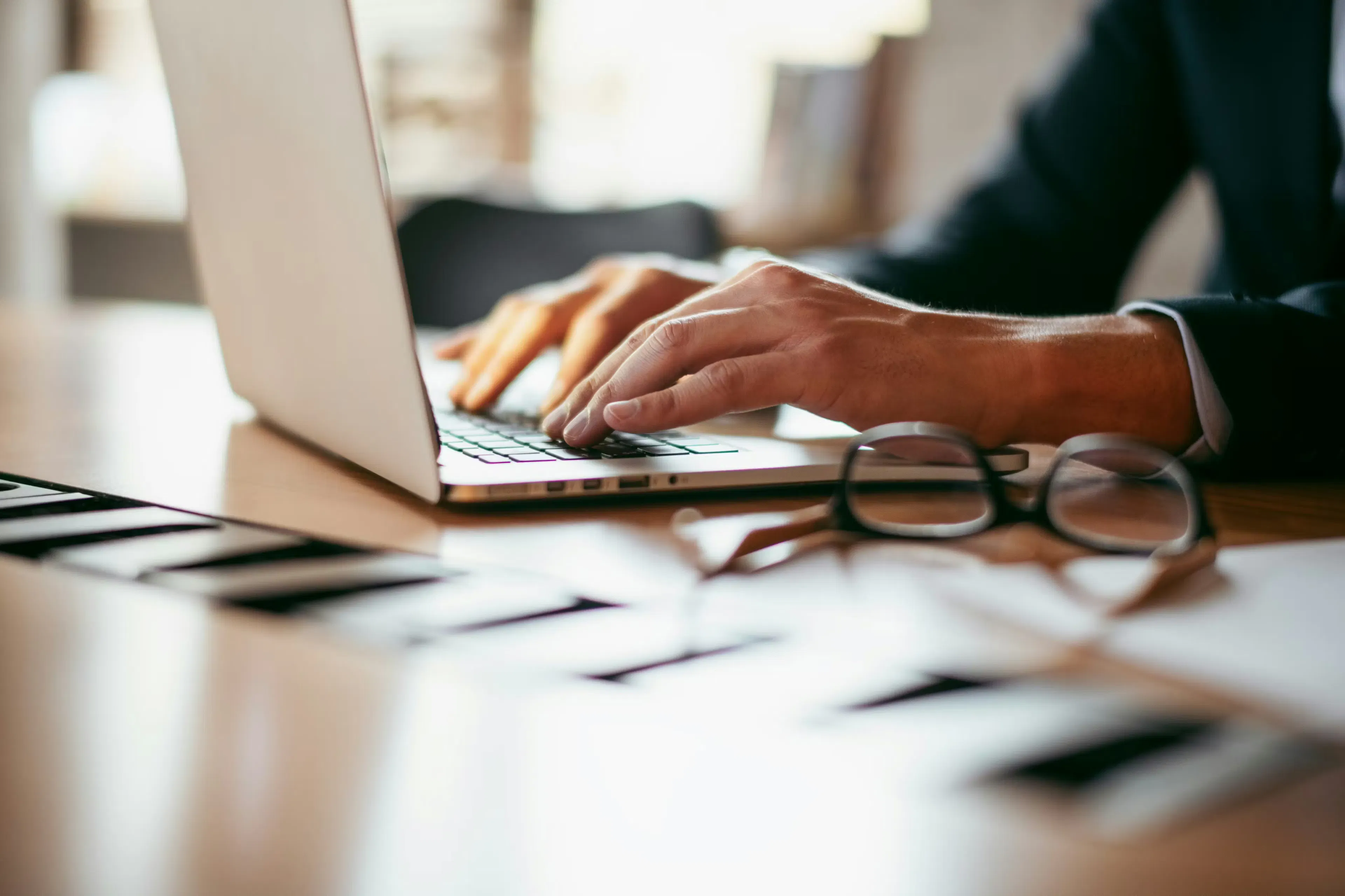 Close-up of hands using a laptop in a modern office, representing secure, self-directed crypto management and non-custodial control.