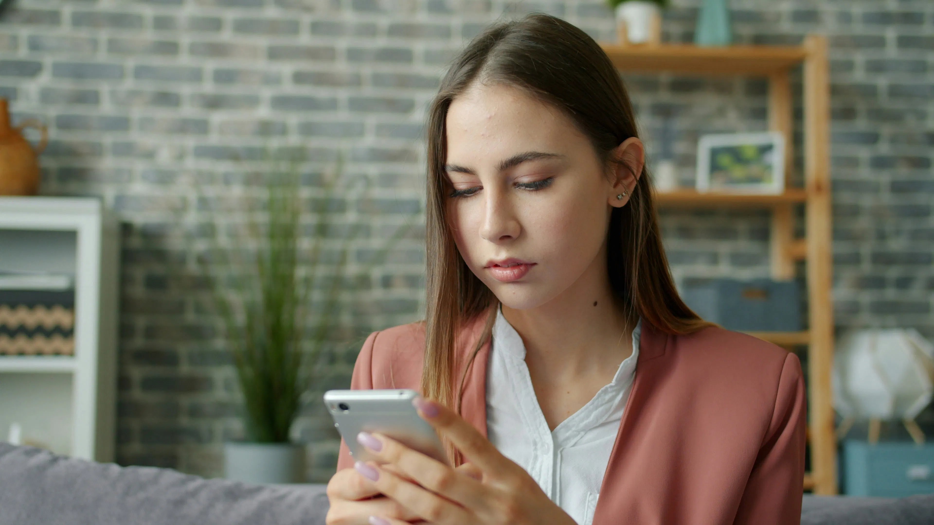 Person checking a smartphone at a desk, representing common crypto mistakes and scam awareness in Canada