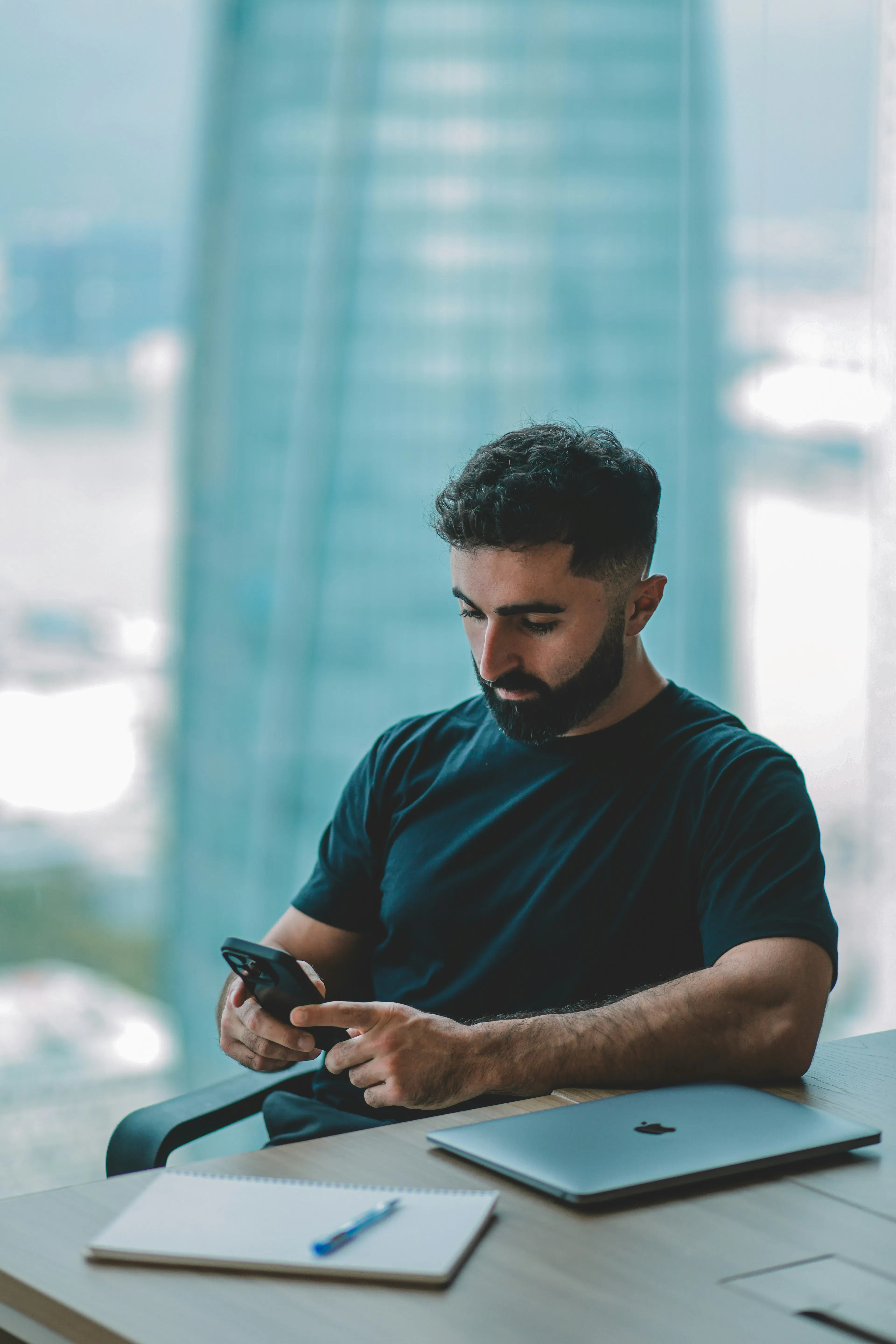 Person checking a smartphone in an office setting, representing cashing out crypto into Canadian dollars
