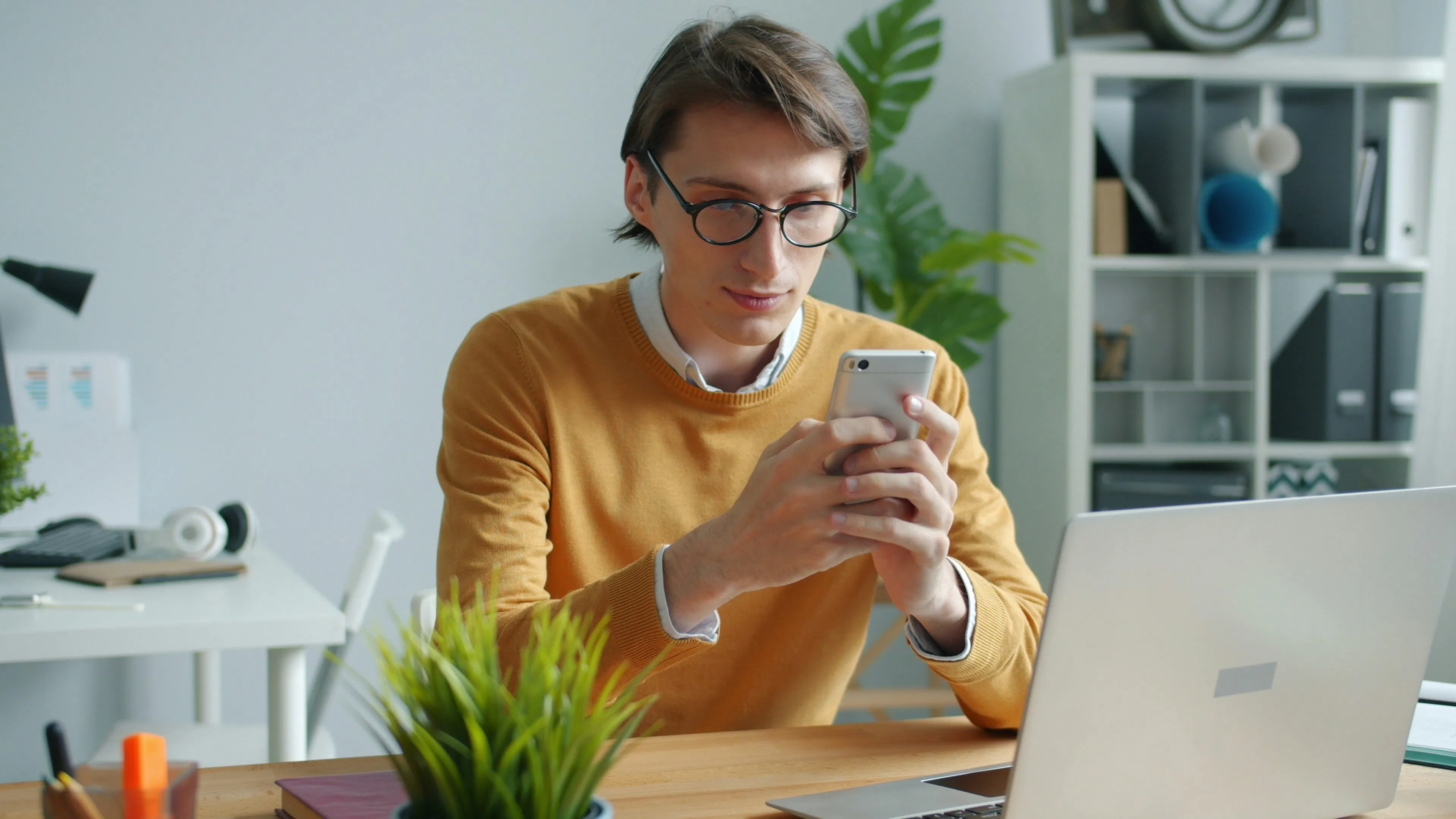 Person reviewing a smartphone at a desk, representing self-custody and control of digital assets in Canada