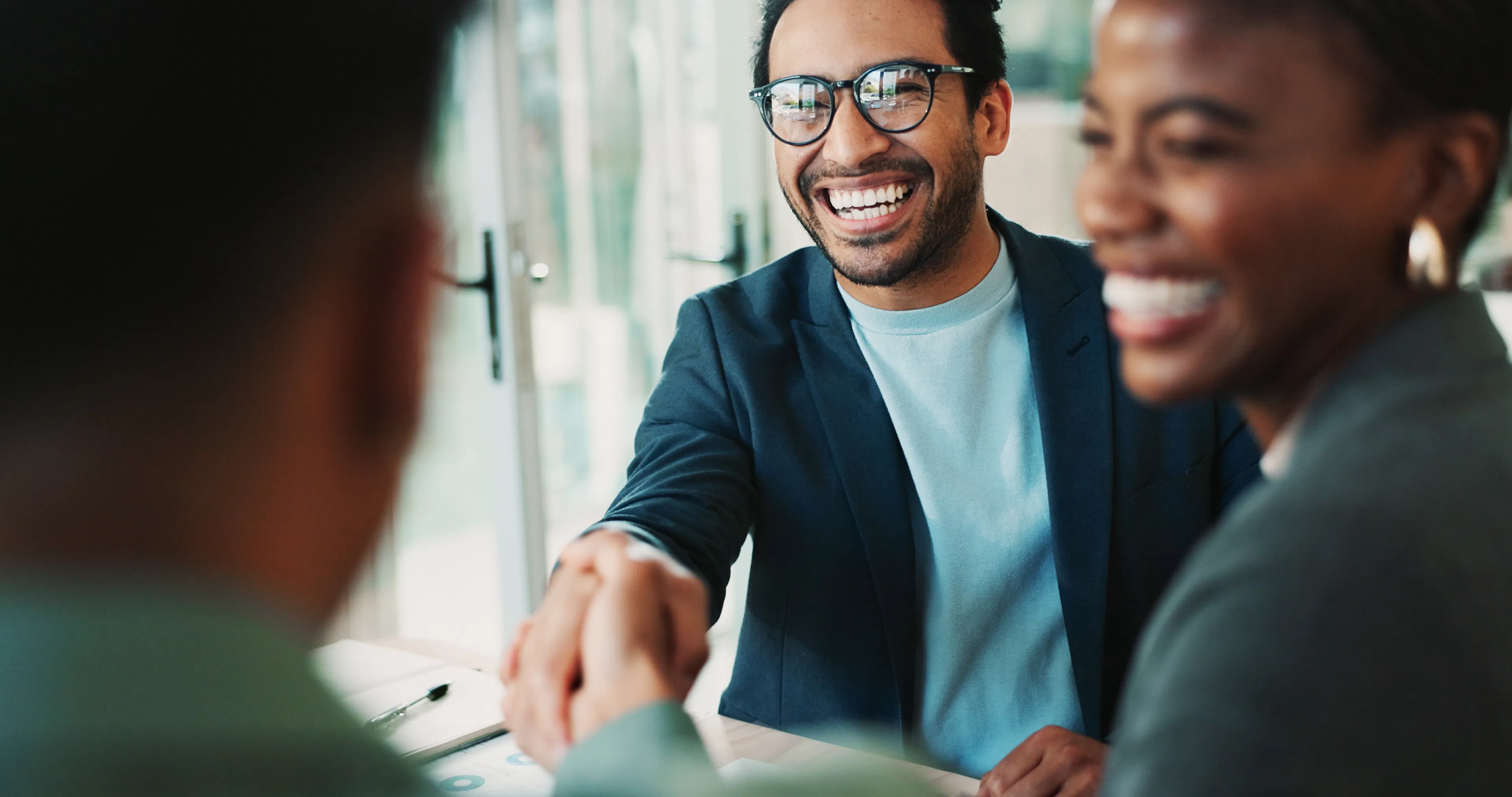 Crypto specialist shaking hands with a smiling couple during a consultation, representing VBX's full-service human support