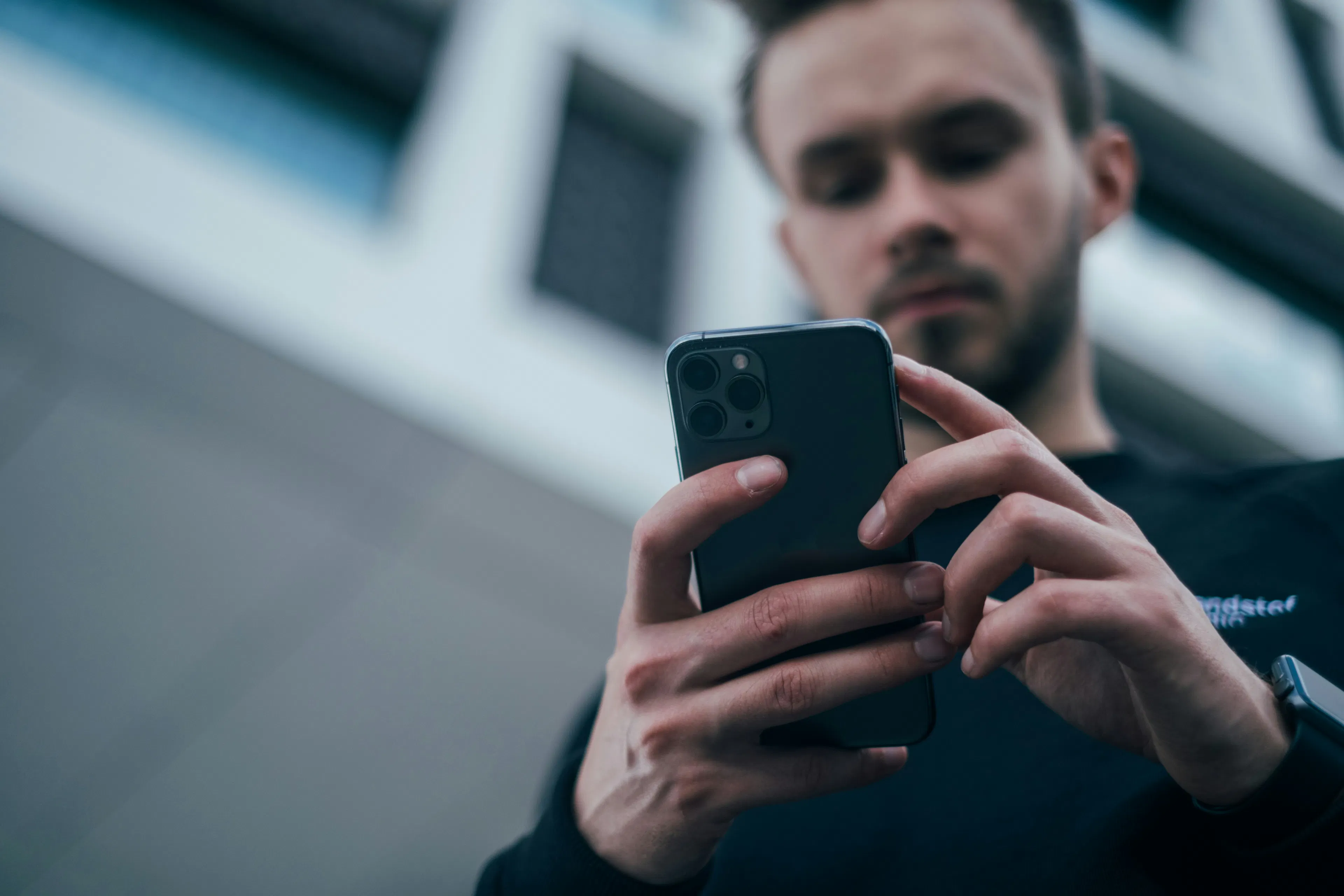 Young man trading on a crypto app on his phone, representing a self-directed active trader who may prefer NDAX