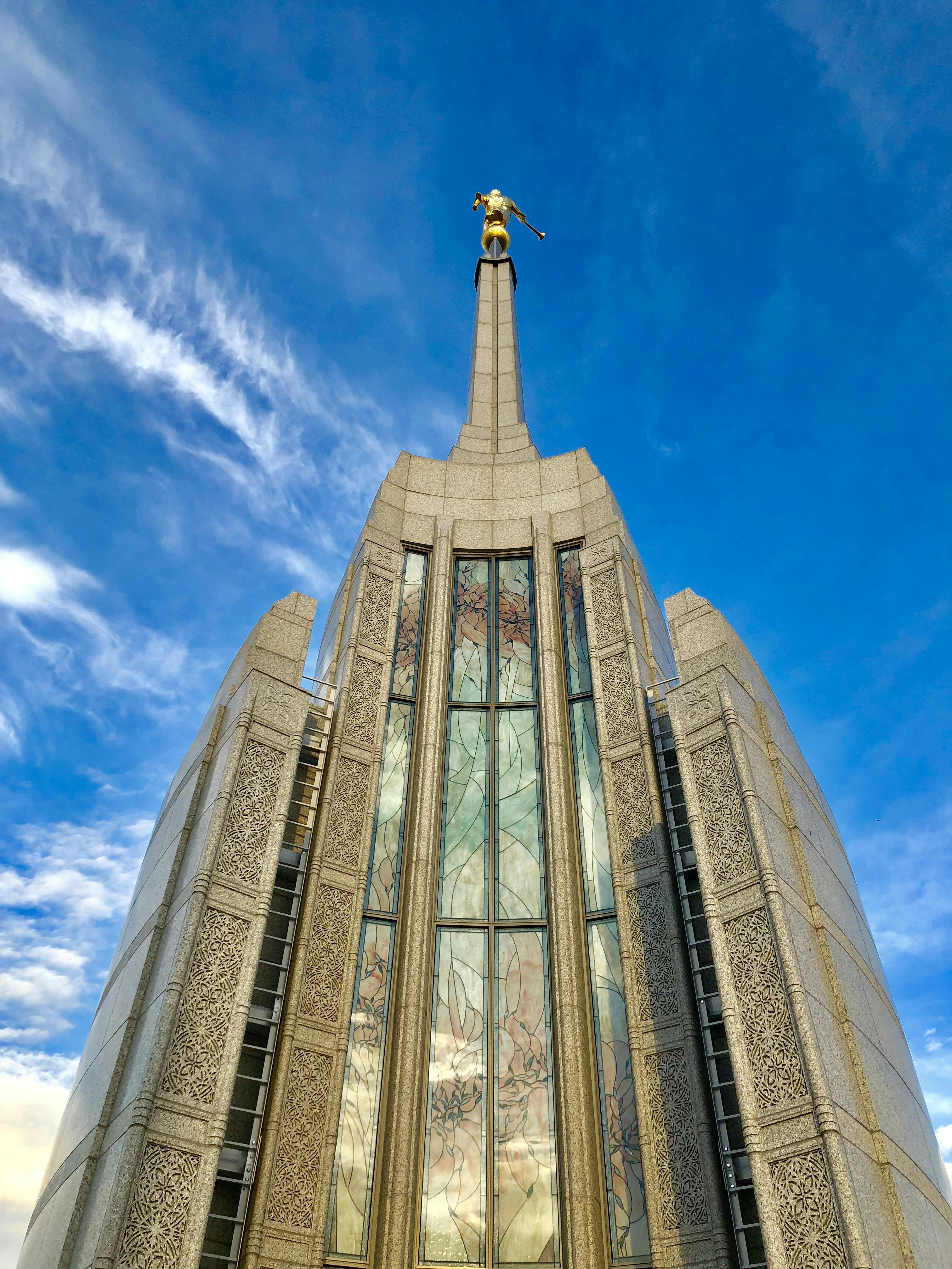 Temple exterior with stained glass and Angel Moroni statue.