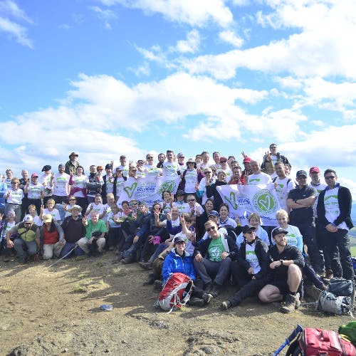 Group of trekkers smiling together on a Patagonian summit.