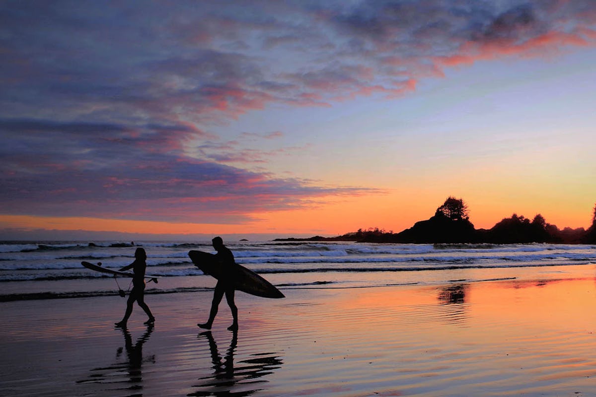Surfers in front of Tofino sunset