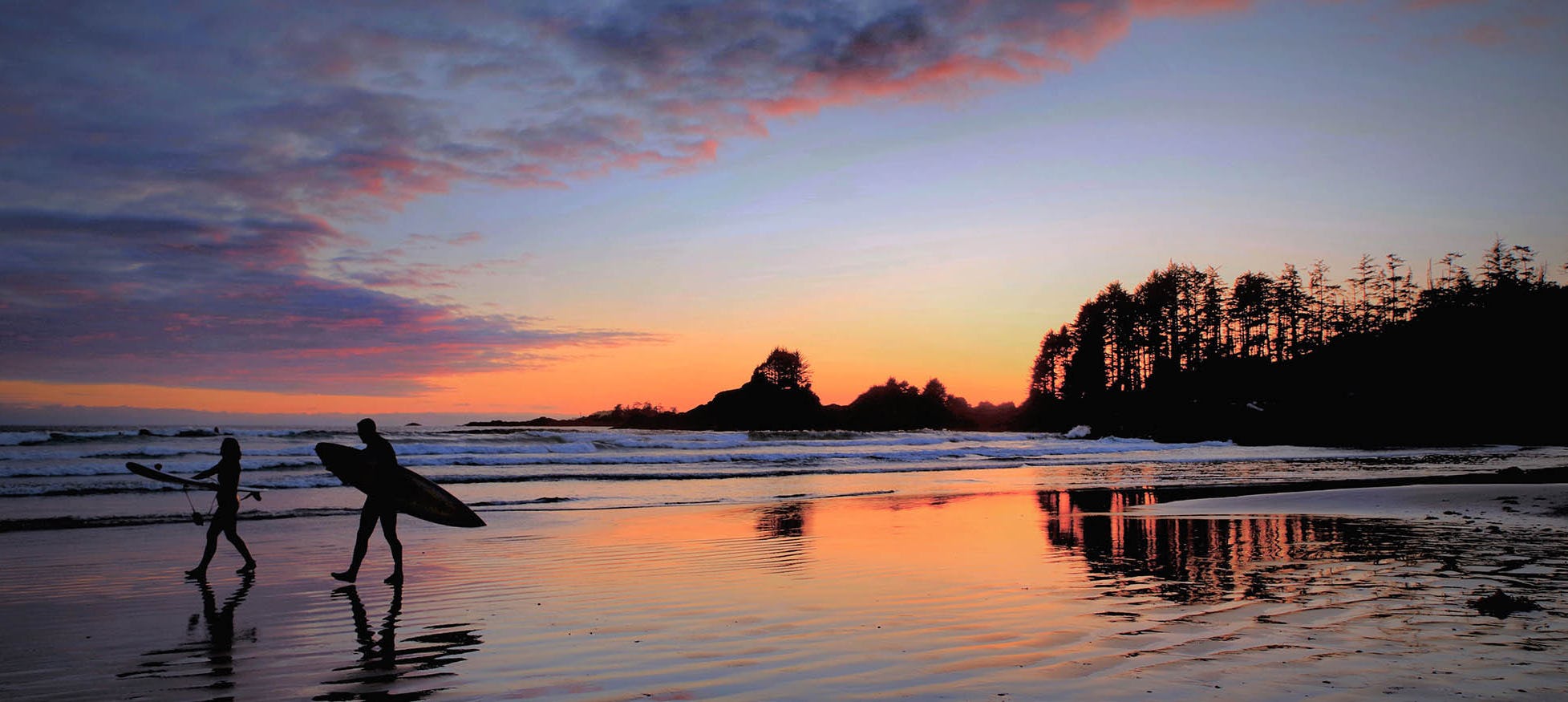 Surfers in front of Tofino sunset