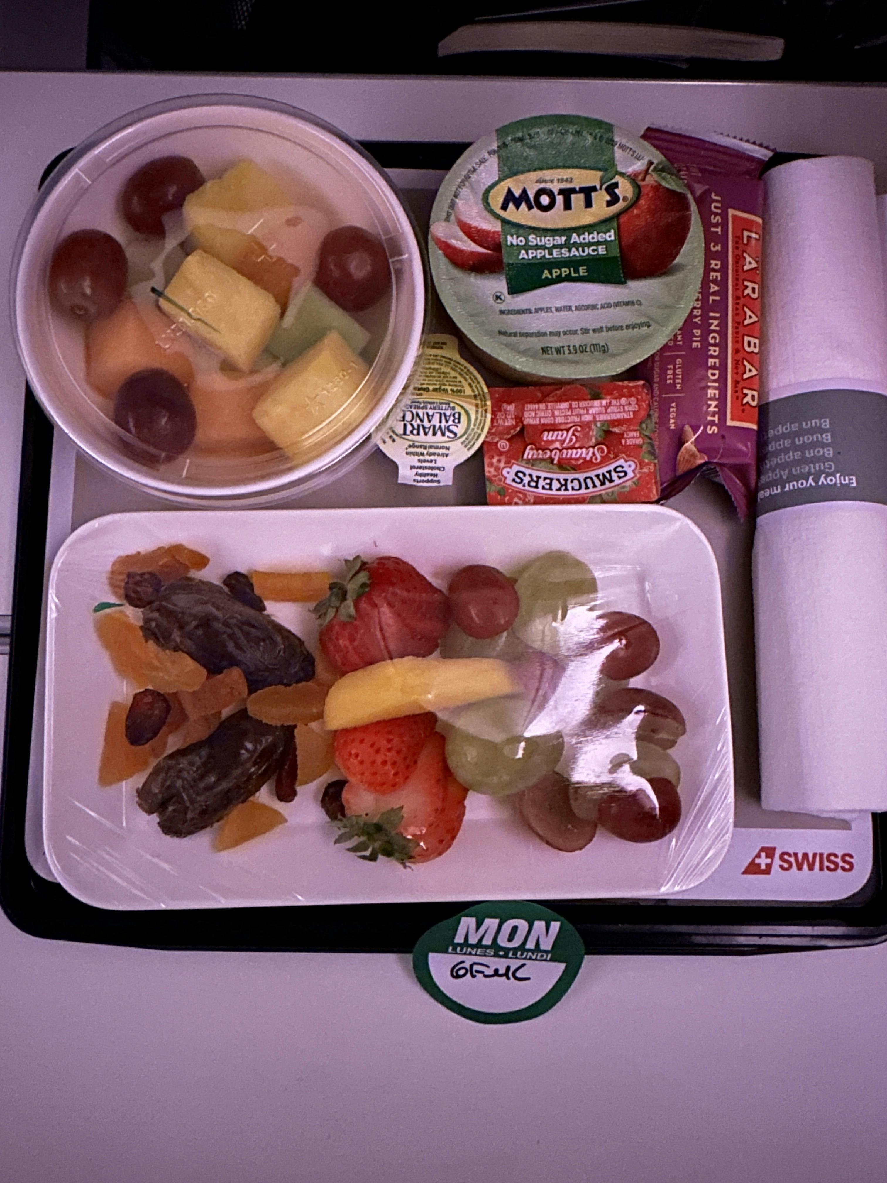 two bowls of fruit with dried fruits, apple sauce, a larabar, and strawberry jam