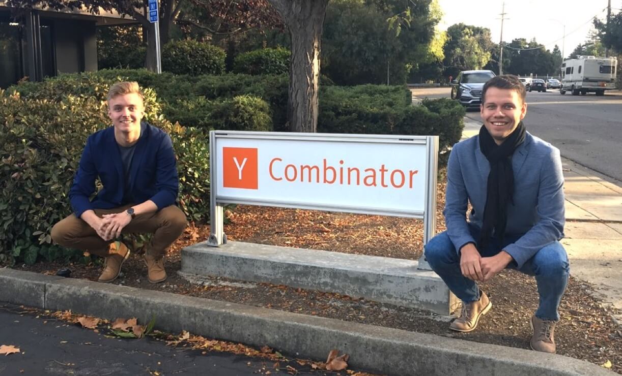Proprietários da Veriff se ajoelhando ao lado de uma placa que diz Y Combinator