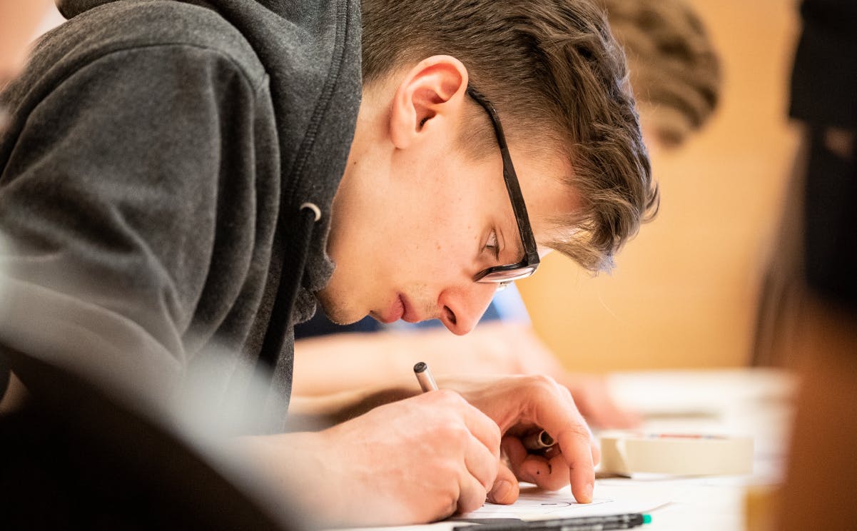 A man in glasses working.