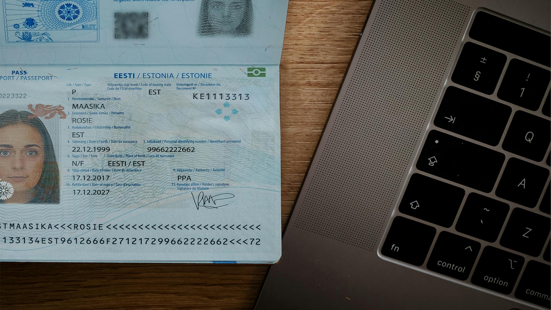 Close up of a passport next to a laptop