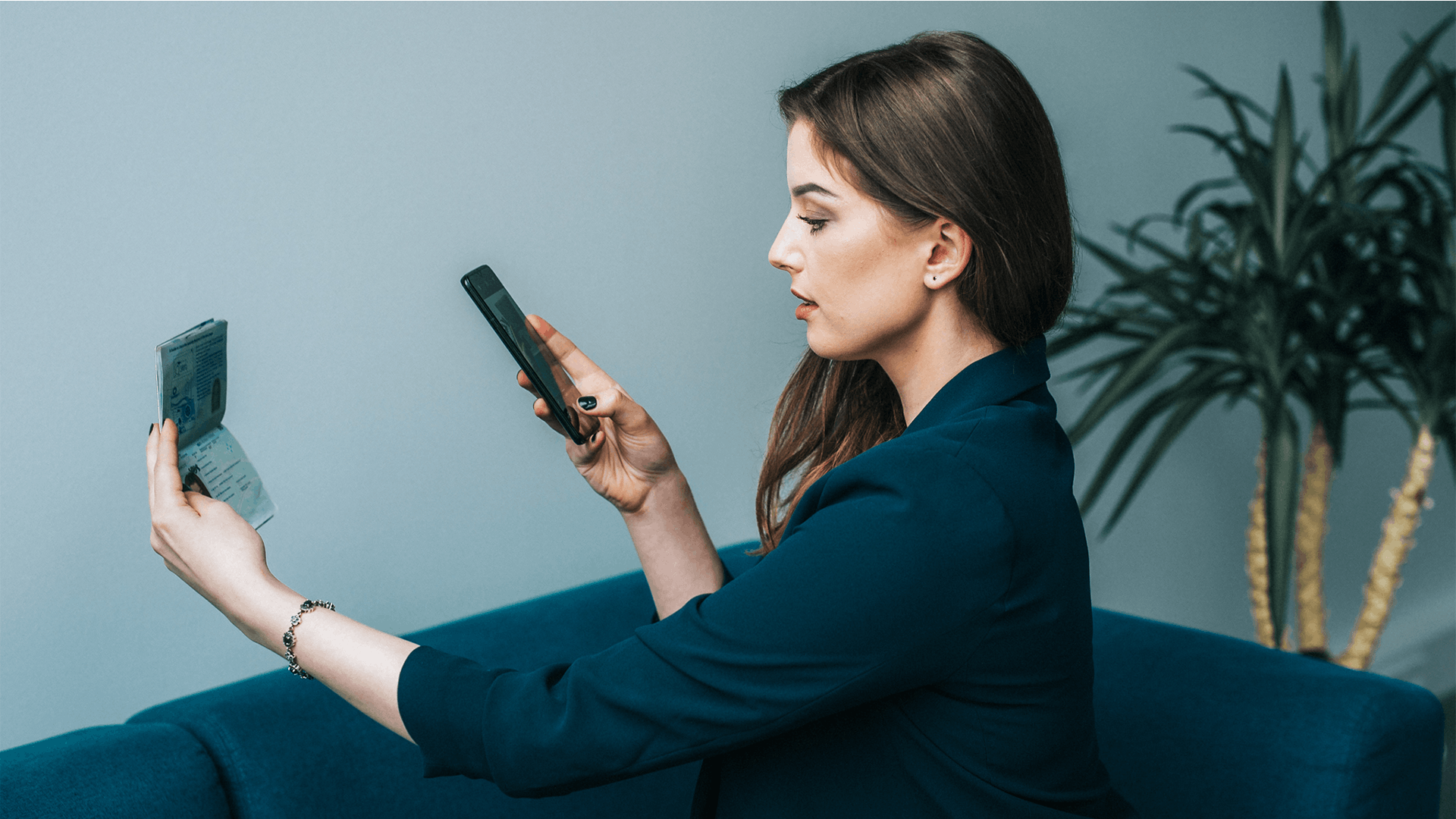 A young woman with dark hair sat down verifying her passport using a smartphone.