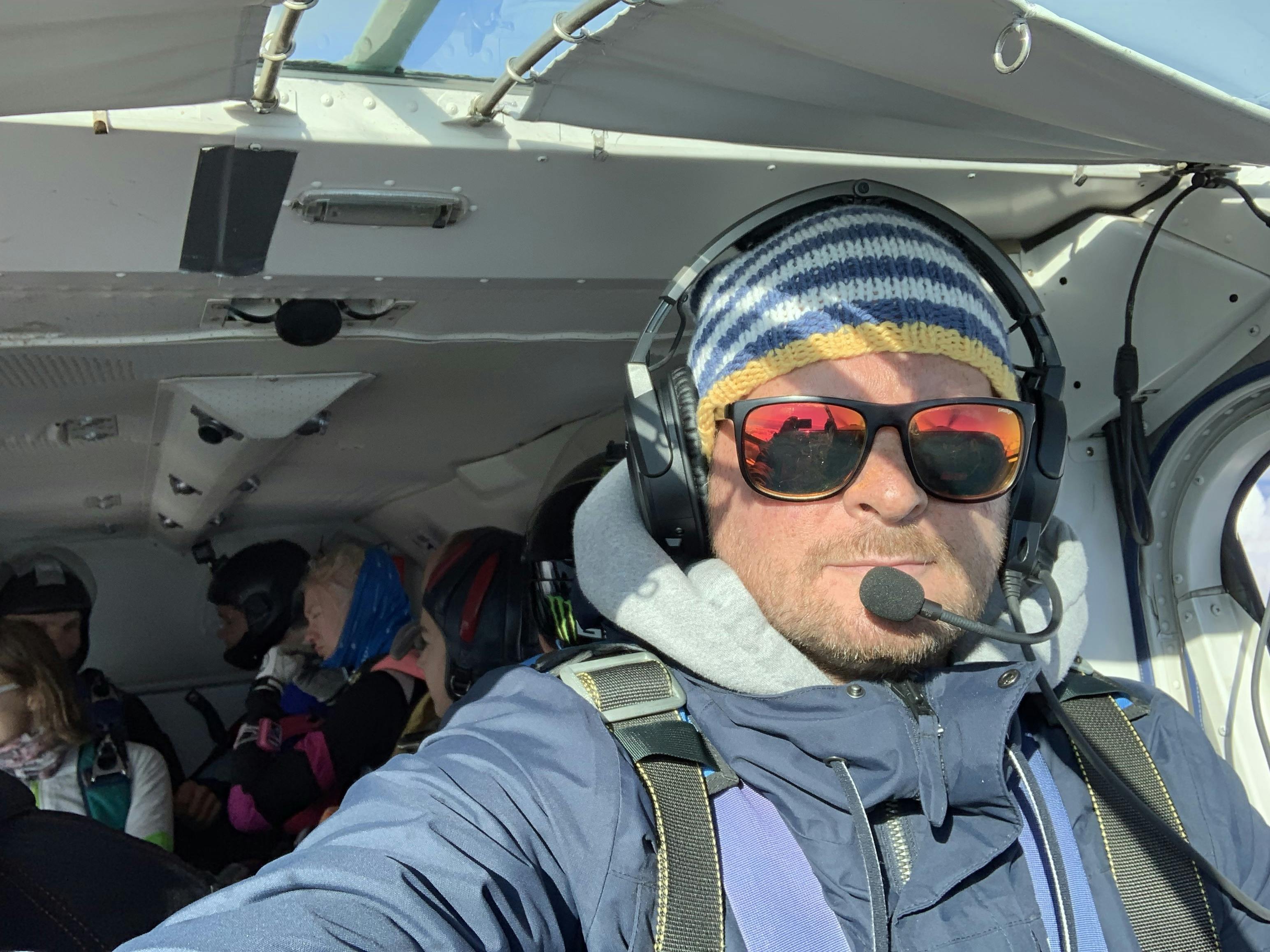 A man with sunglasses on in a plane