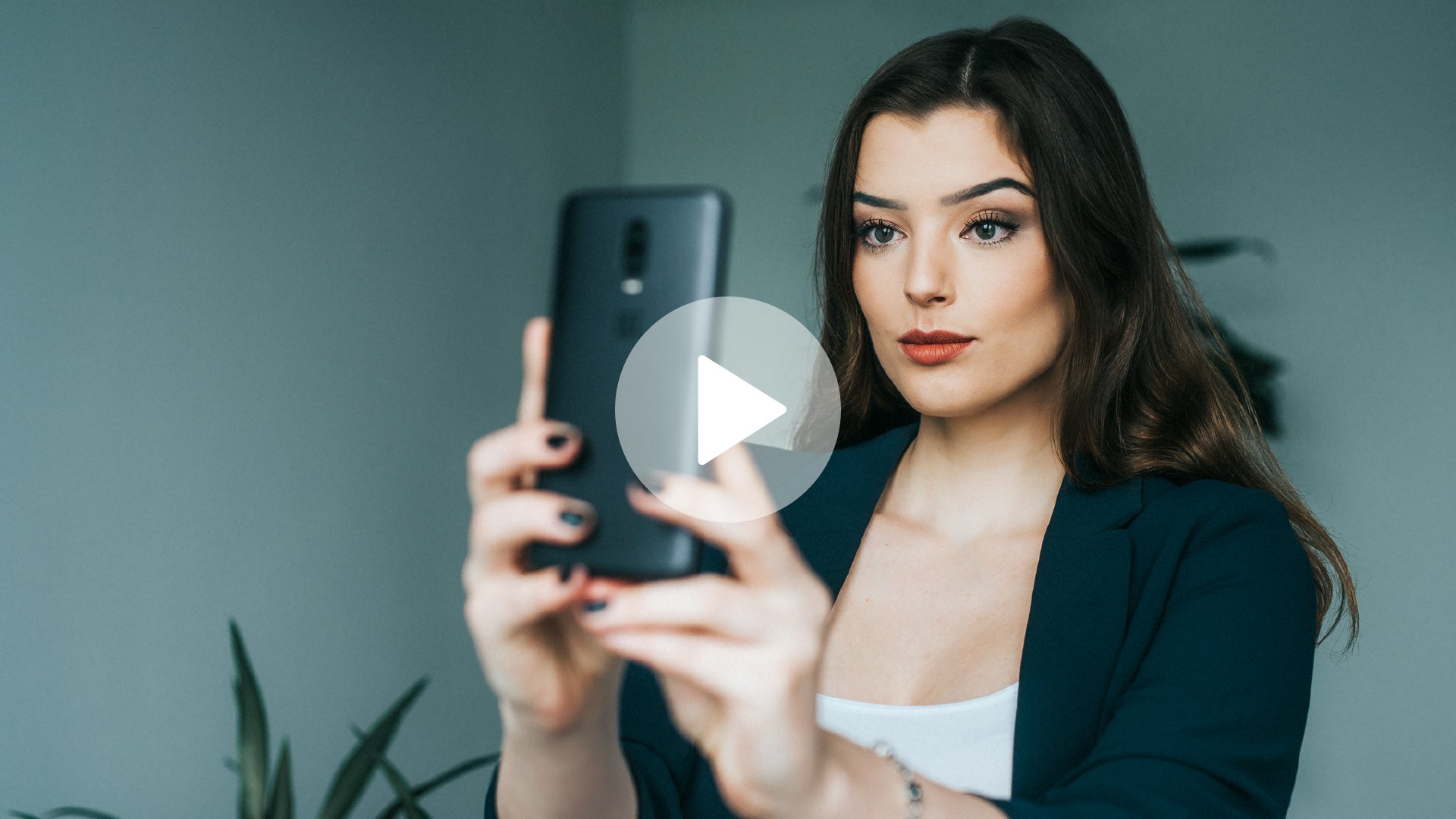 A young woman with dark hair taking a selfie