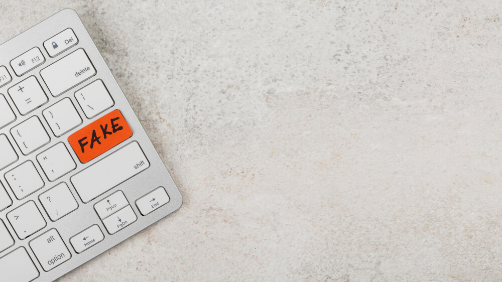 White Keyboard with a Orange Return Key with 'Fake' Written Over it
