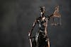Bronze statue of Lady Justice holding scales and a sword, symbolizing fairness and impartiality in the legal system.