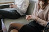 Couple sitting apart from each other removing their wedding rings