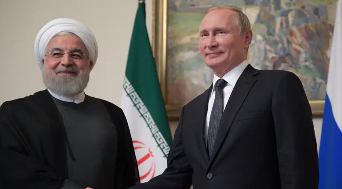 Russian President Vladimir Putin shakes hands with Iranian President Hassan Rouhani