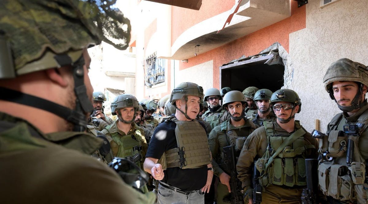 Prime Minister Benjamin Netanyahu (center) speaks with soldiers inside the northern Gaza Strip