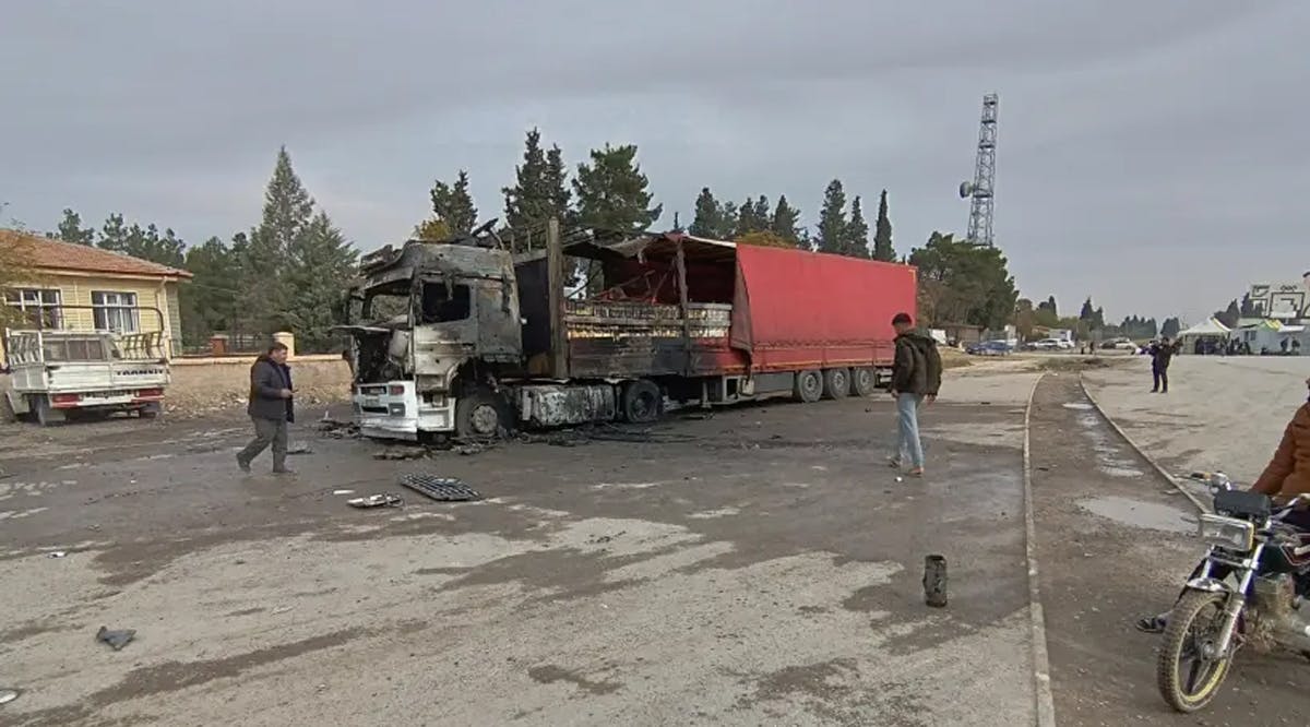 Locals inspect a burned truck hit by one of the rockets fired from northern Syria in the Karkamis district, near a border gate in Gaziantep province, Turkey