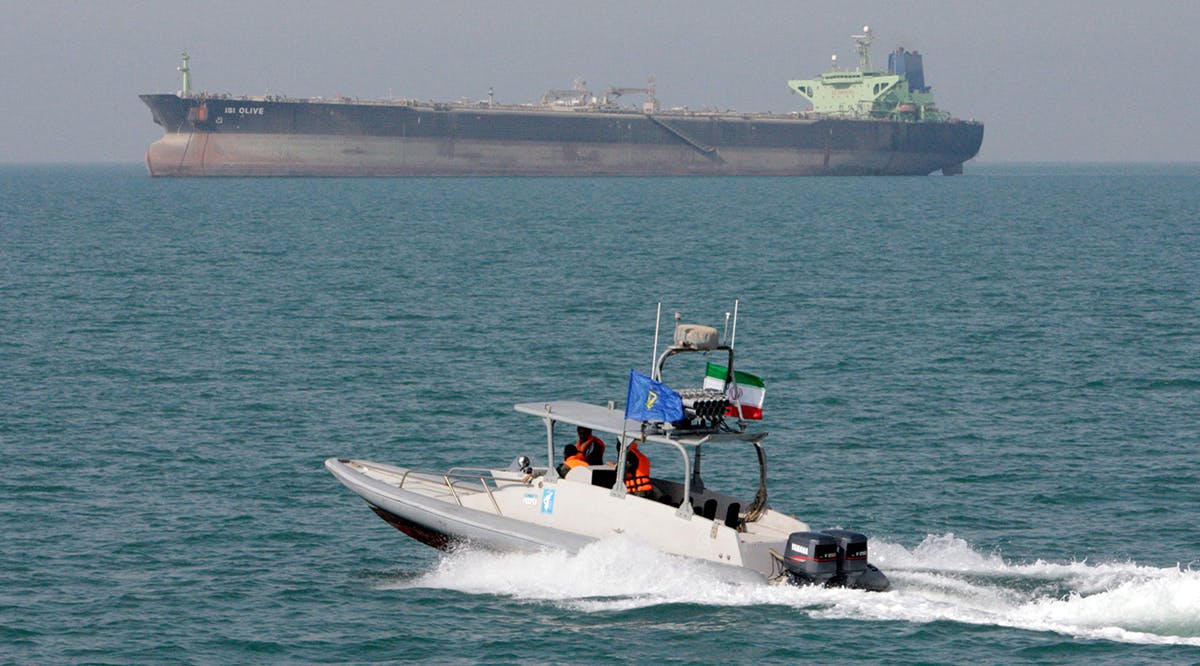 An Iranian Revolutionary Guard speedboat moves in the Persian Gulf while an oil tanker is seen in background