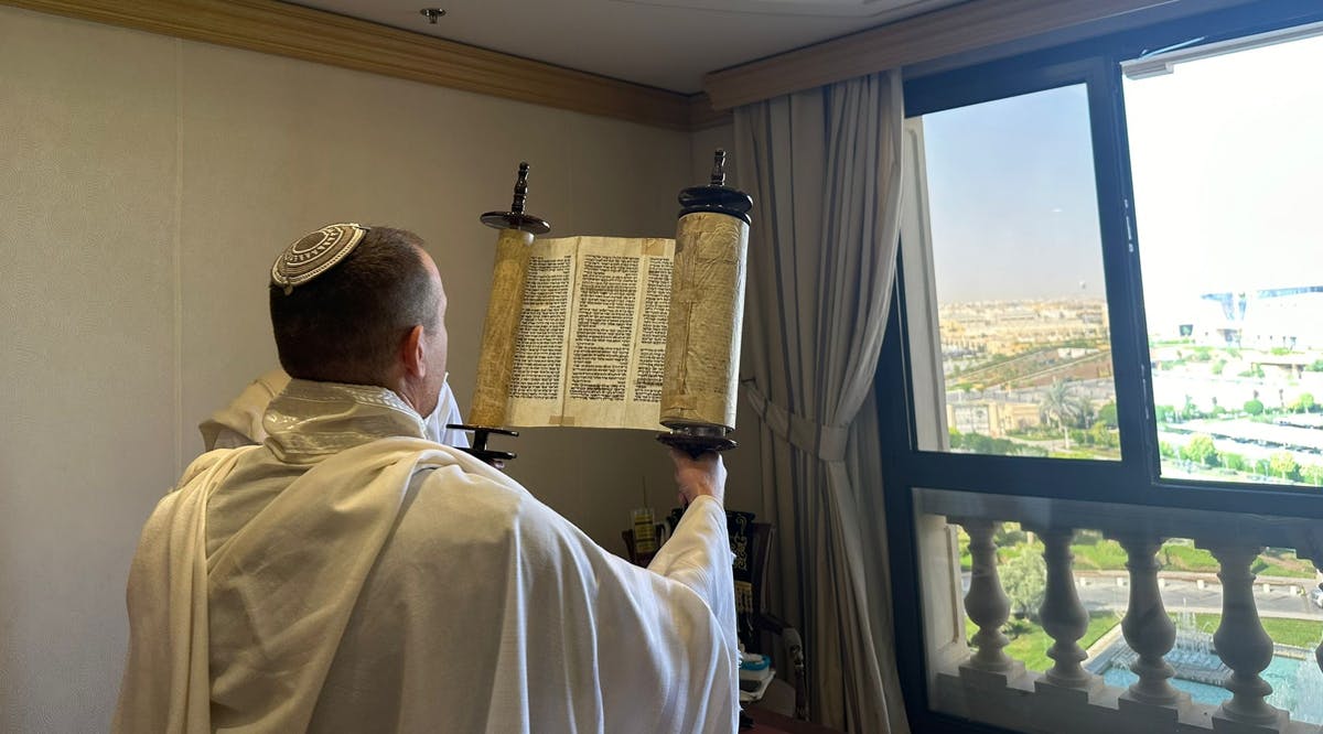 A member of Communications Minister Shlomo Karhi's delegation holds up a Torah scroll during a morning prayer service in Riyadh, Saudi Arabia