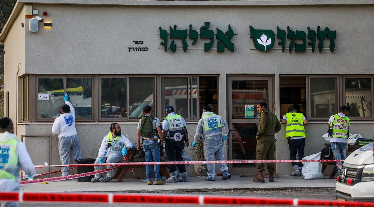 Israeli security personnel and ZAKA rescue and recovery organization workers at the scene of a deadly shooting attack near the Jewish community of Eli in Samaria