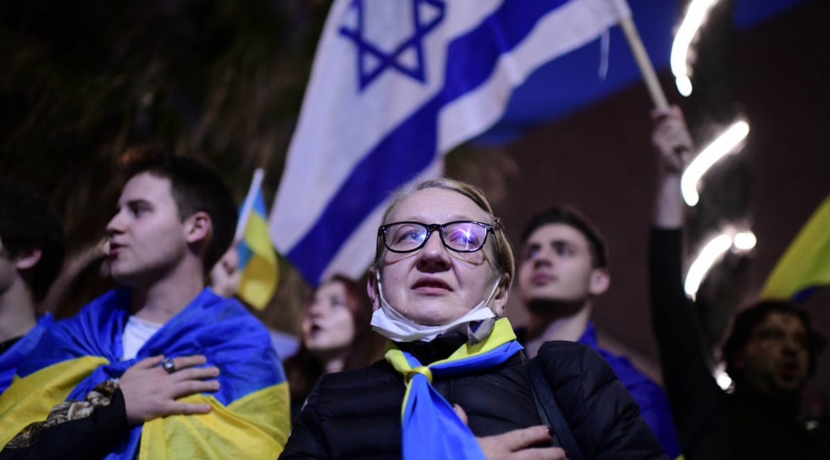 Demonstrators carry placards and flags during a protest against the Russian invasion of Ukraine, outside the Russian Embassy in Tel Aviv