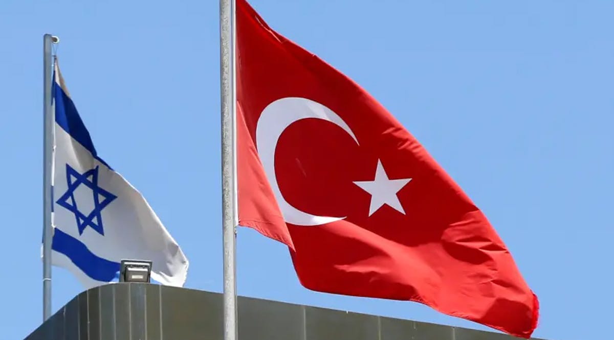 A Turkish flag flutters atop the Turkish embassy as an Israeli flag is seen nearby, in Tel Aviv