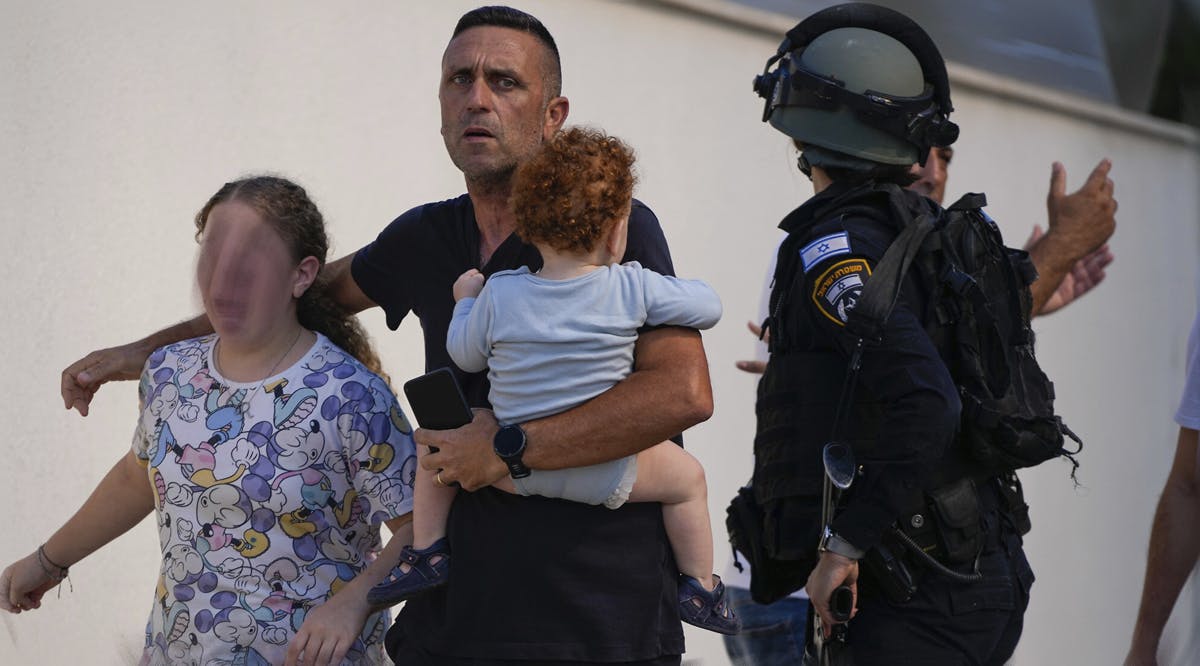 Israeli police officers evacuate a family from a site hit by a rocket fired from the Gaza Strip, in Ashkelon