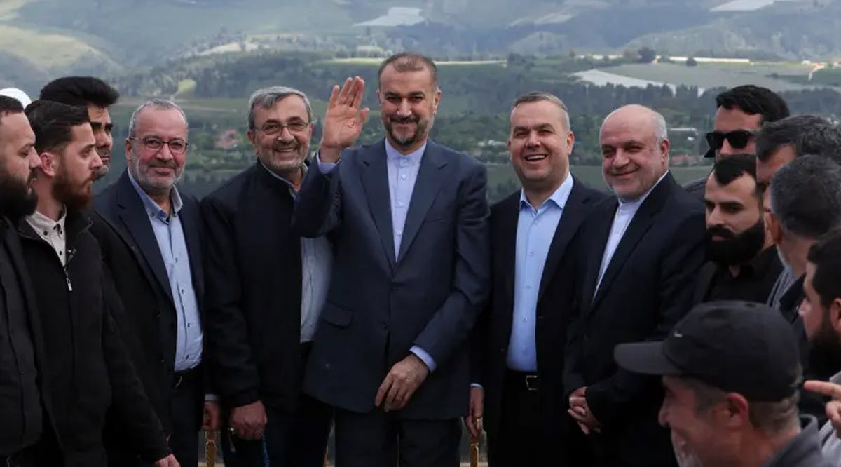 Iranian Foreign Minister Hossein Amirabdollahian gestures as he stands next to Hezbollah officials during his visit to Maroun Al-Ras village near the border between Lebanon and Israel