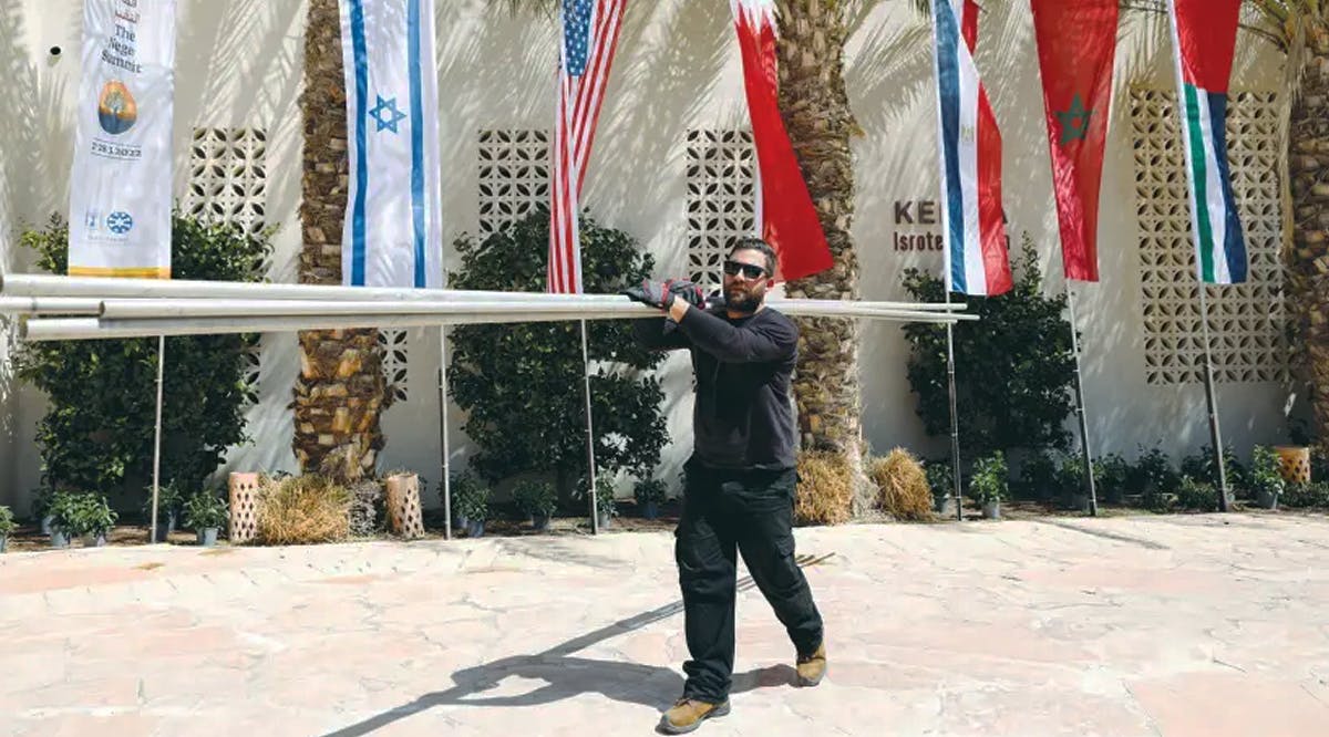 A WORKER carries flagpoles in preparation for the Negev Summit in Sde Boker