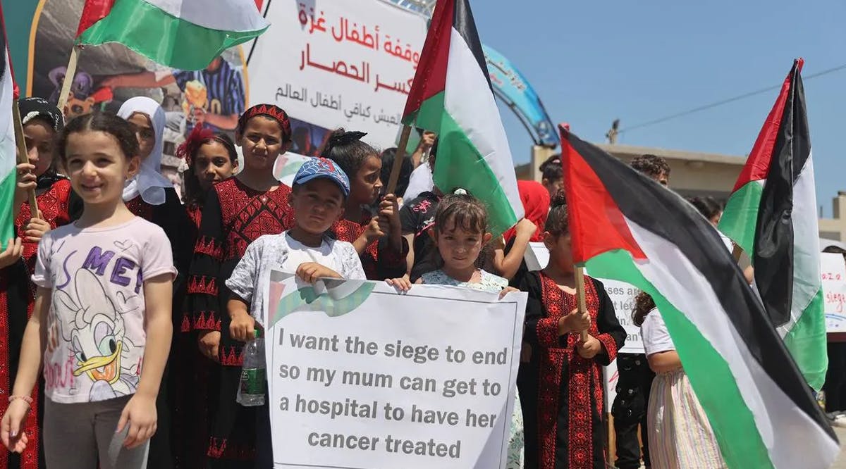A group of Palestinian children carrying banners