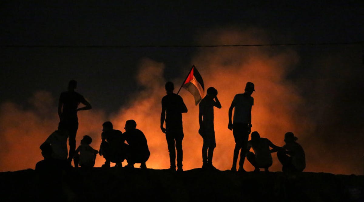 Palestinians protest at night time near the border with Israel, east of Khan Yunis in the southern Gaza Strip