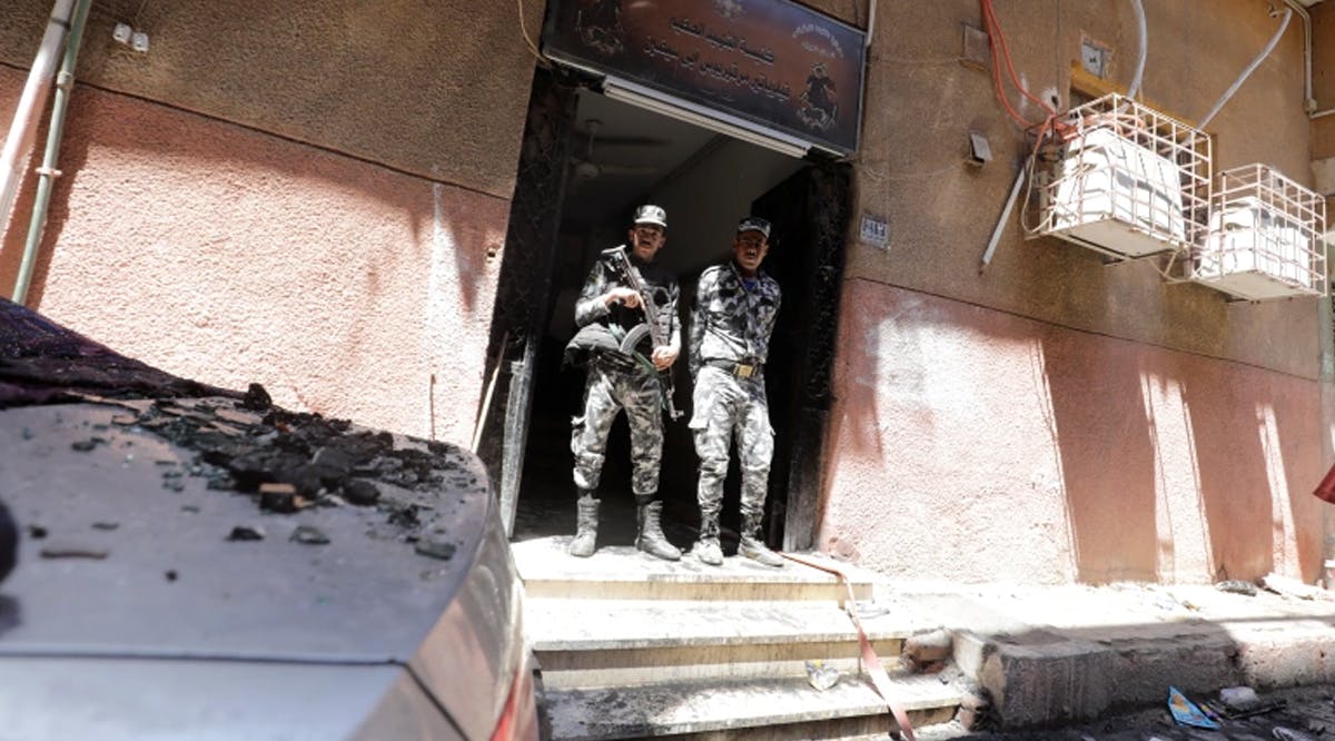 Security members stand at the scene where a deadly fire broke out at the Abu Sifin church in Giza, Egypt