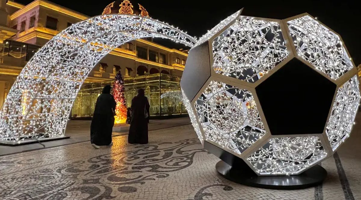 People walk past an illuminated soccer ball ahead of the FIFA 2022 World cup soccer tournament at Katara Cultural Village in Doha, Qatar