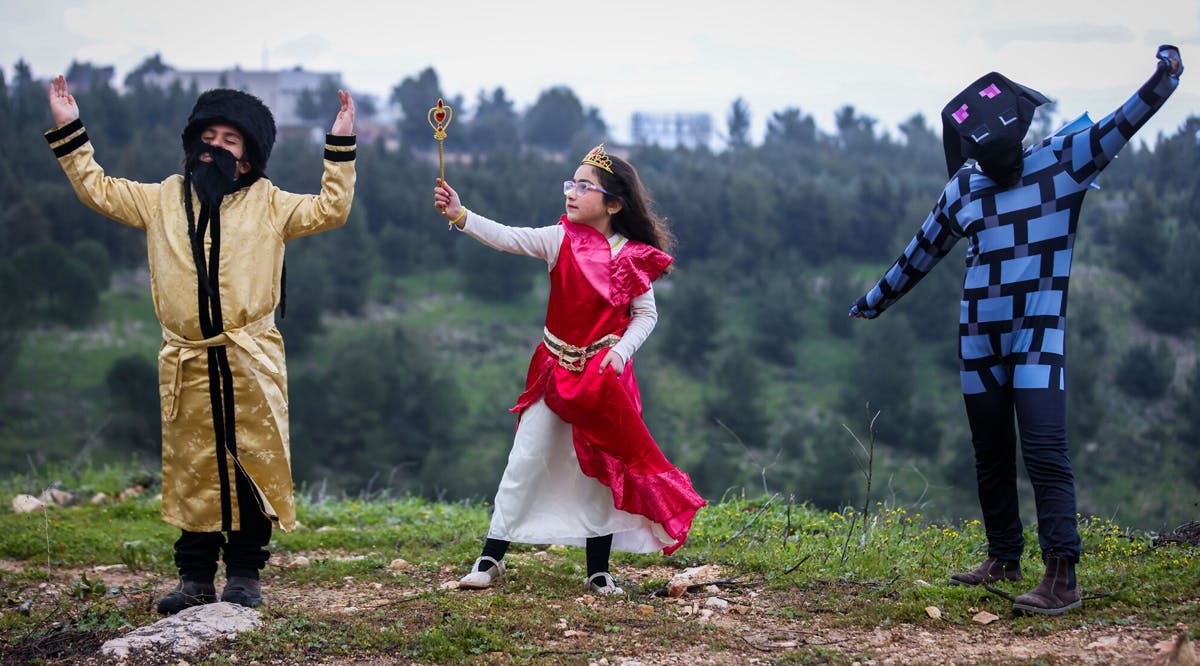 Children dressed in costumes pose for a picture in the northern city of Safed, ahead of the the Jewish holiday of Purim