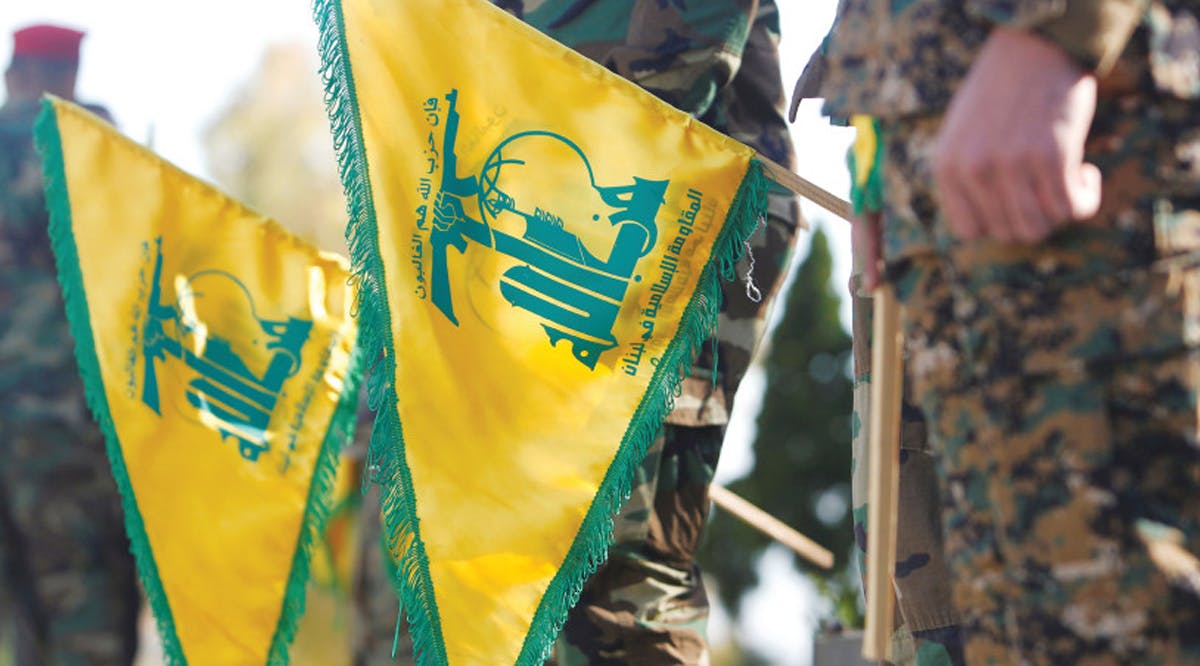 HEZBOLLAH MEMBERS hold flags marking Resistance and Liberation Day, in Kfar Kila near the Lebanese border with Israel