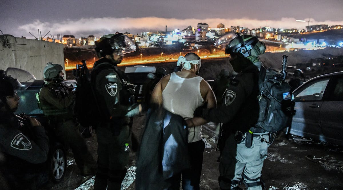 Officers detain a Palestinian man in the Shuafat refugee camp in East Jerusalem