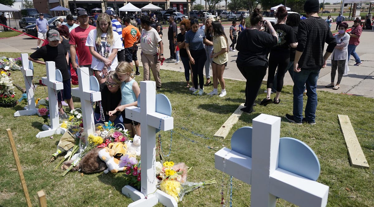 People look on at a makeshift memorial by the mall where several people were killed in Saturday's mass shooting, Monday, May 8, 2023, in Allen, Texas
