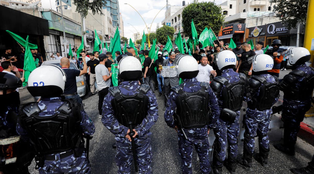 Palestinian forces stand guard as Palestinian Hamas supporters take part in an anti-Israel rally