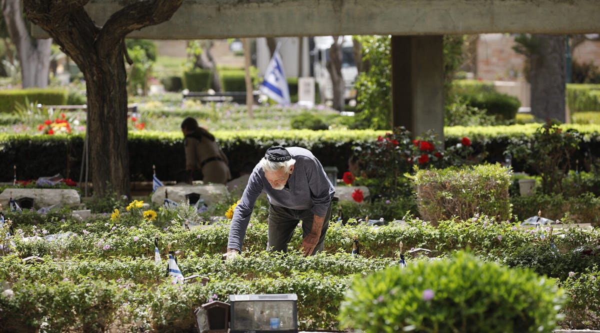A man visits a grave of a loved one at the military cemetery in Haifa