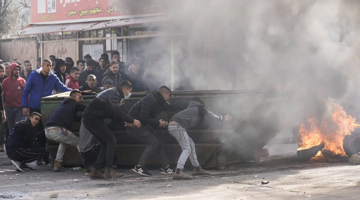 Palestinians clash with Israeli forces following an army raid in the West Bank city of Jenin