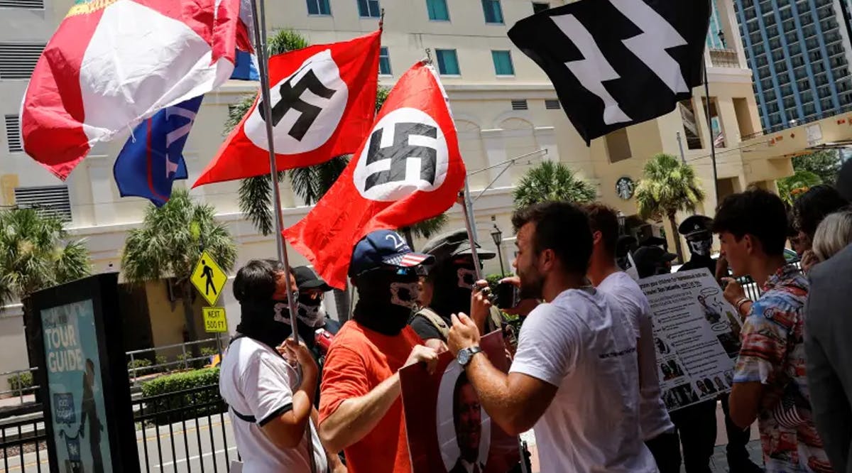 People waving Nazi swastika flags argue with conservatives during a protest outside the Tampa Convention Center