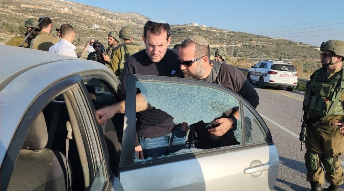 Samaria Regional Council chair Yossi Dagan inspects damage caused to an Israeli-owned car following a shooting attack near the Havat Gilad outpost in the northern West Bank