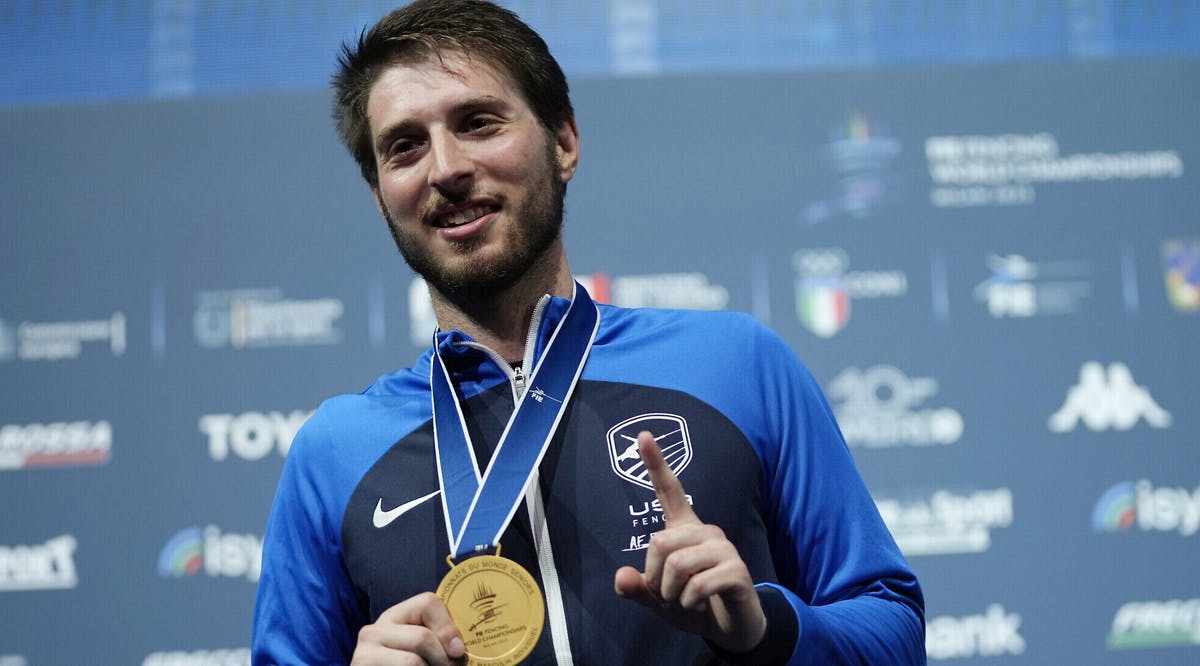 Eli Dershwitz, of the United States, celebrates on the podium after winning the men's Individual Sabre final at the Fencing World Championships in Milan, Italy